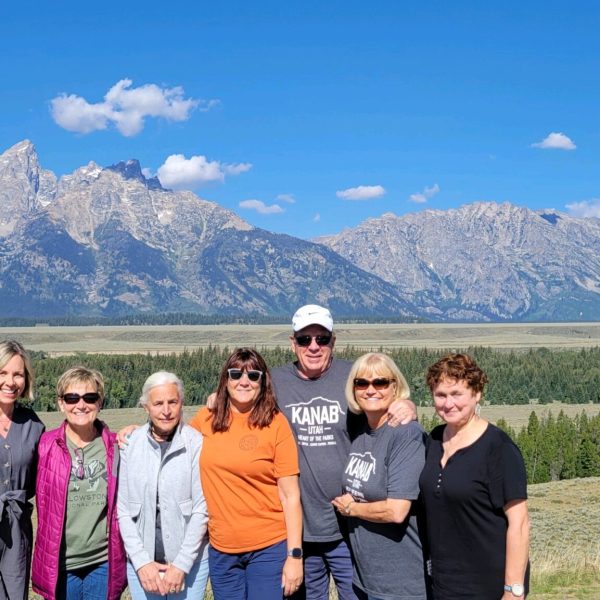 a group of people posing for a photo in front of a mountain