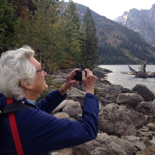 a man holding a stuffed animal on a rock
