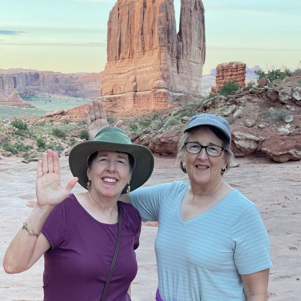 a couple of people that are standing in front of a mountain