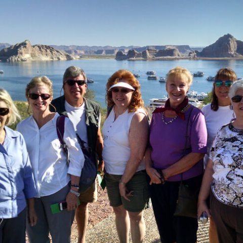 a group of people standing next to a body of water