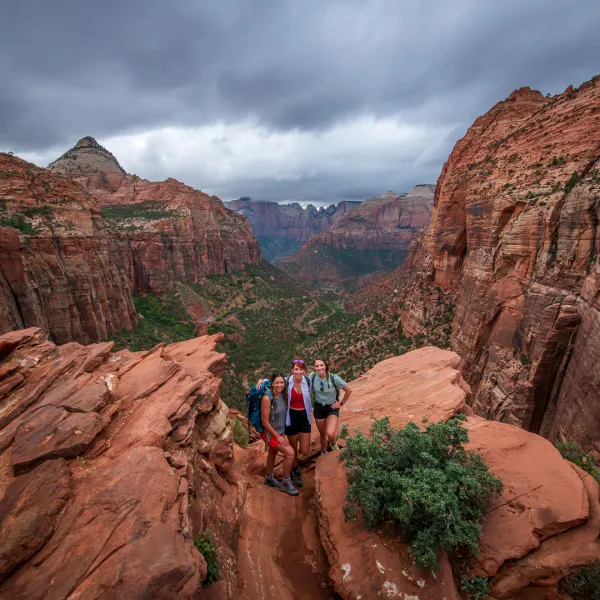 a person standing on a rocky hill with Zion National Park in the background